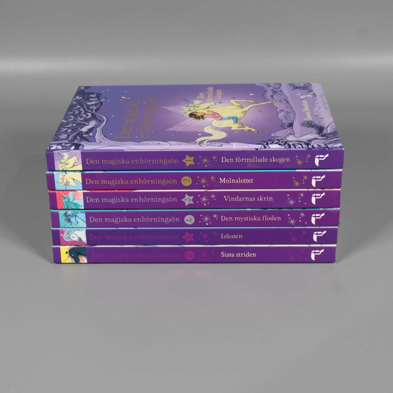 Sex böcker ur serien staplade, visar titlarna på ryggarna