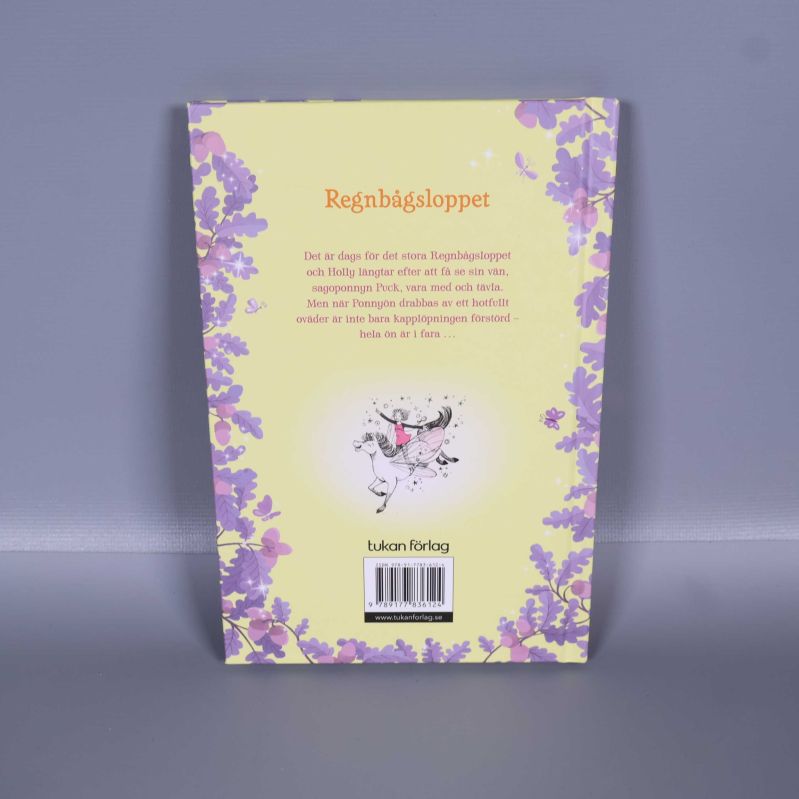 Baksidan av boken Den förtrollade ponnyön med beskrivande text och streckkod