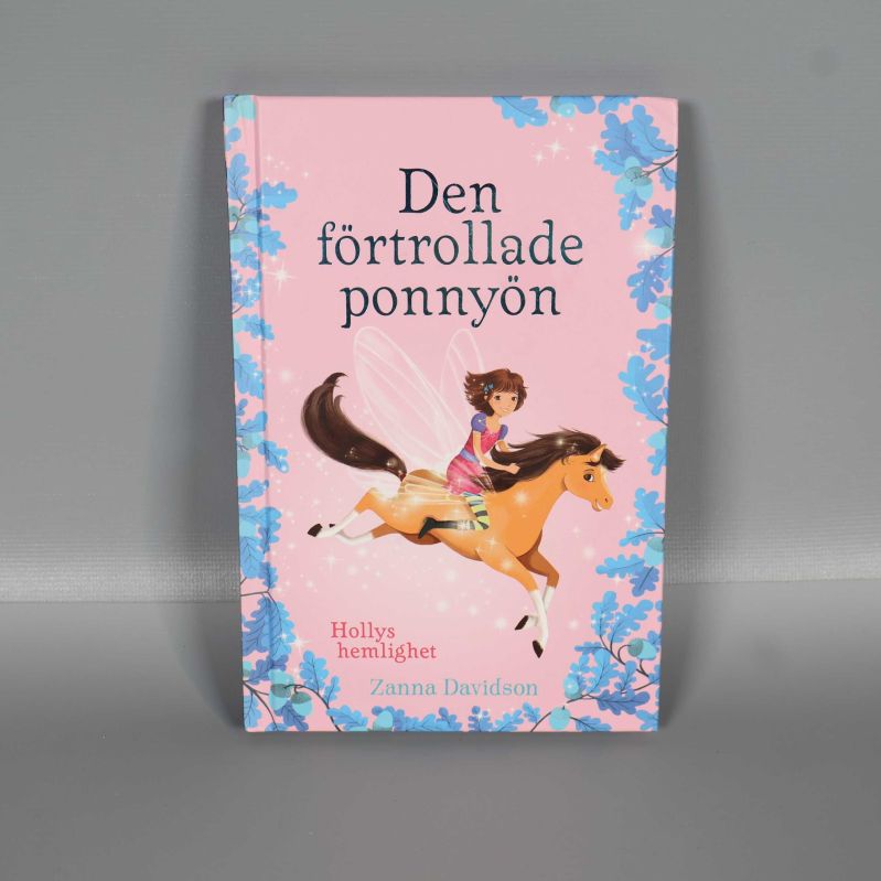 Framsida av Den förtrollade ponnyön med illustration av flicka på ponny