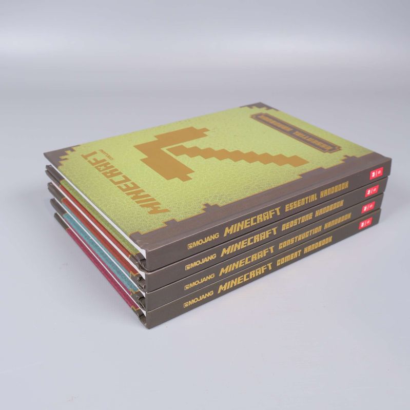 Fyra staplade Minecraft handböcker med synliga ryggar och framsida