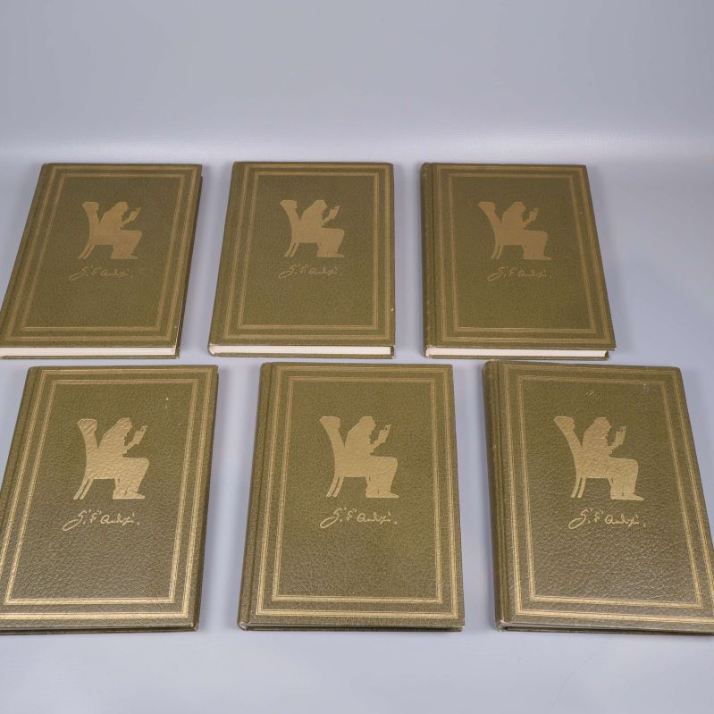 Fem böcker med guldfolierade pärmar och silhuett på framsidan