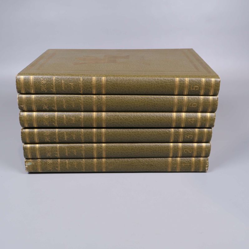 Böcker staplade med synliga ryggar och guldtext på varje volym