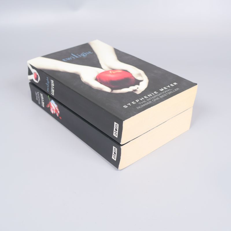 Två pocketböcker staplade med bokryggar synliga