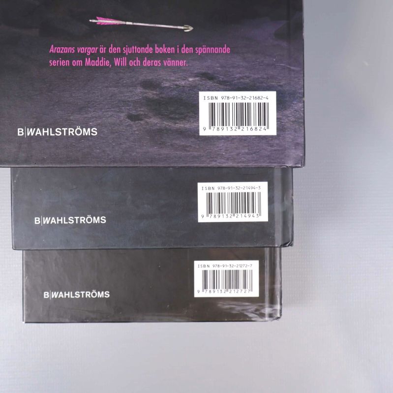 Närbild på baksidor med tre olika ISBN-nummer för Spejarens lärling