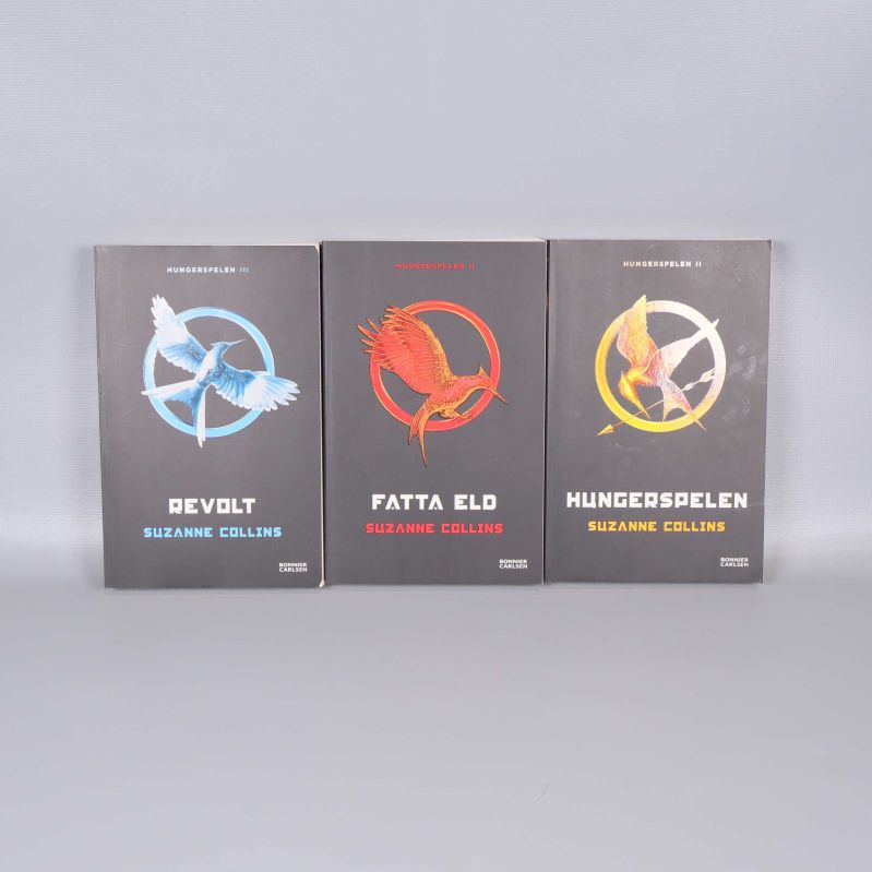 Framsidor av böckerna Revolt, Fatta eld och Hungerspelen