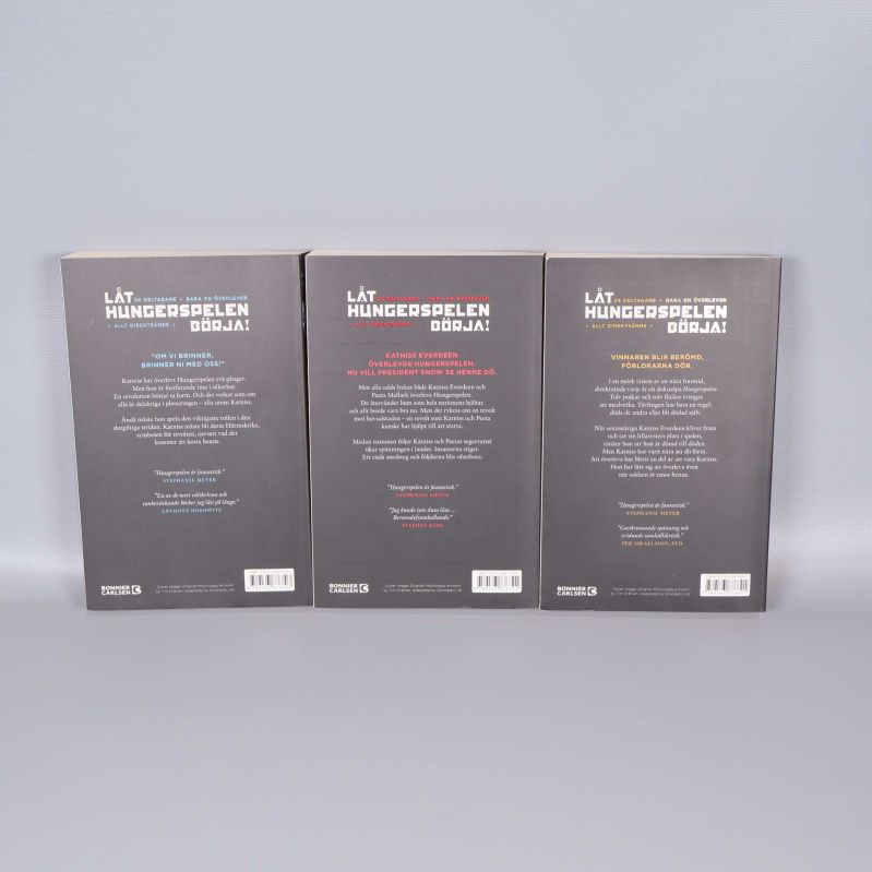 Baksidor på trilogins tre böcker med texter