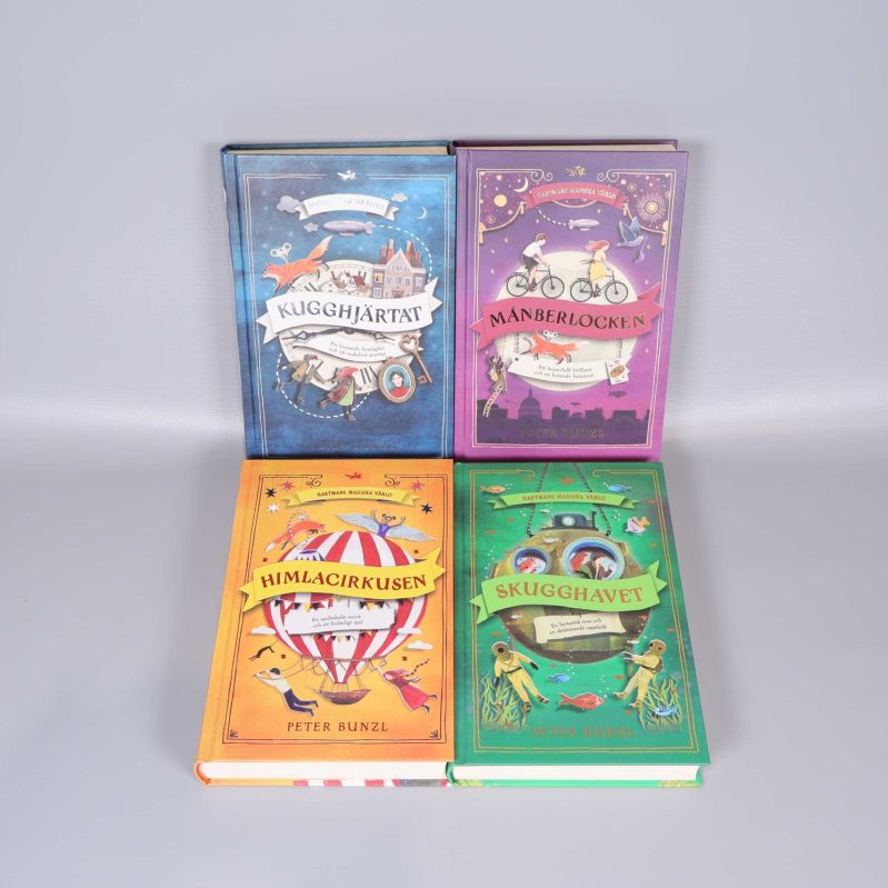 Fyra inbundna böcker ur Hartmans magiska värld liggande uppslagna