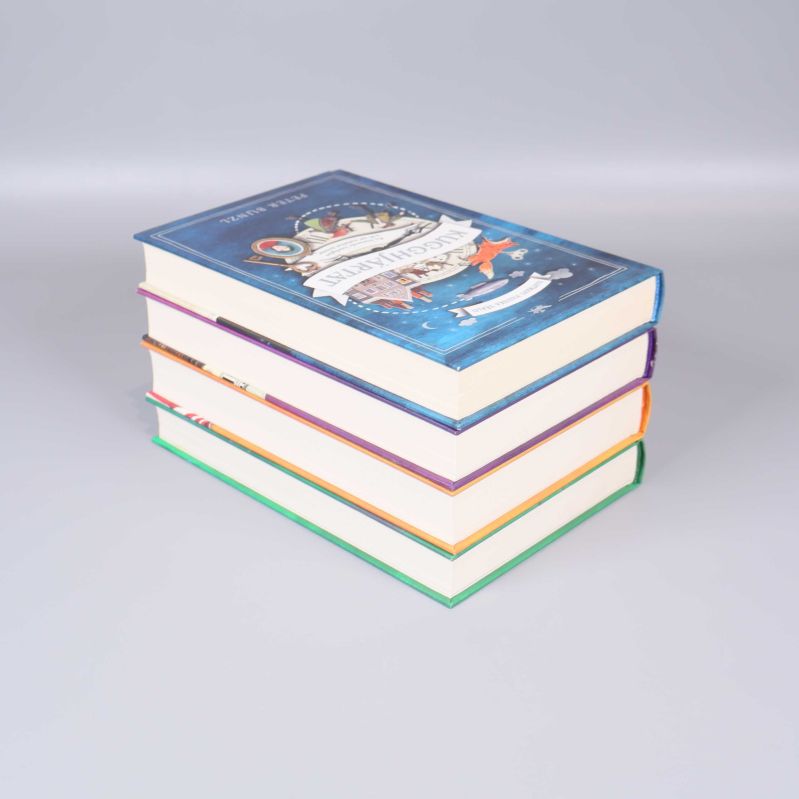 Böcker ur Hartmans magiska värld staplade på varandra, sett snett ovanifrån