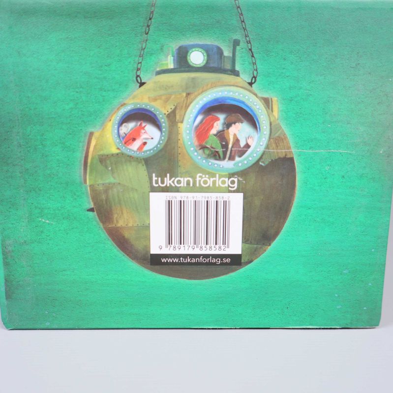 Närbild på baksidan av boxen med illustration och synlig ISBN-kod