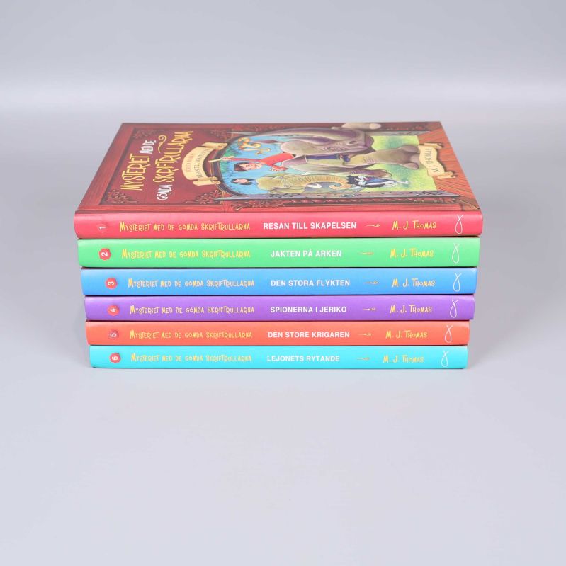 Bokryggar med titlar i olika färger och namnet M.J. Thomas