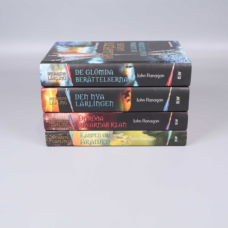 Ryggarna av fyra böcker Spejarens lärling staplade i sidovy