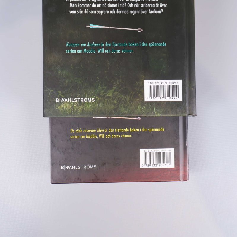 Närbild på två andra baksidor med ISBN på Spejarens lärling böcker