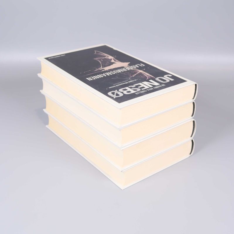 Fyra tjocka inbundna böcker staplade med sidorna utåt