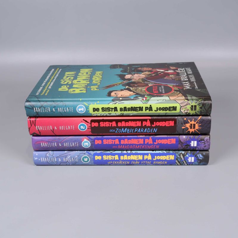 Bokryggar med titlar och färgkoder från De sista barnen på jorden, staplade på rad