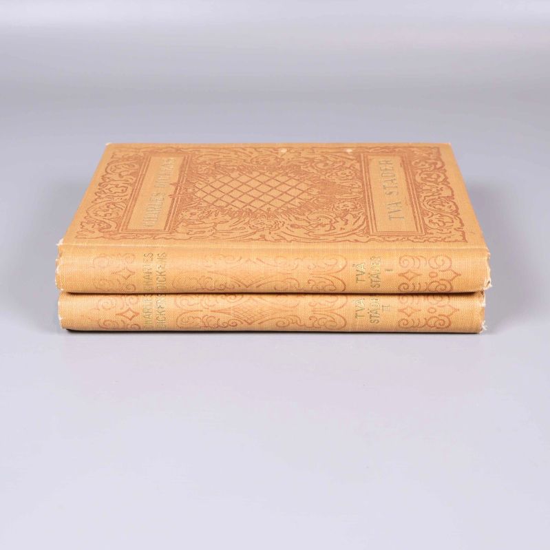 Två böcker staplade med ryggen synlig, texten Två städer tydligt präglad