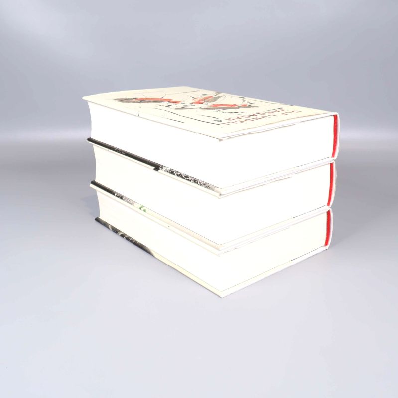 Bokpaket med tre inbundna böcker staplade på sidan