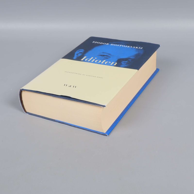 Boken Idioten liggande, visar hårdbandets tjocklek