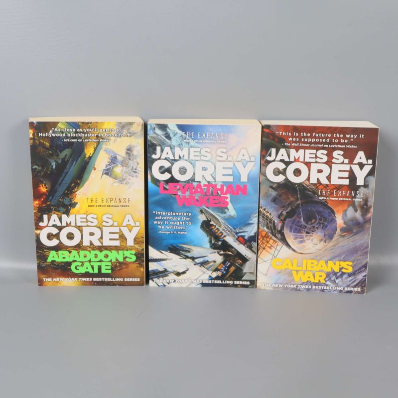 Tre böcker ur The Expanse-serien stående sida vid sida