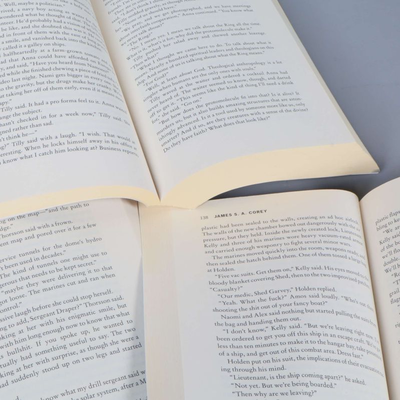 Uppslagna sidor ur de tre böckerna med engelsk text