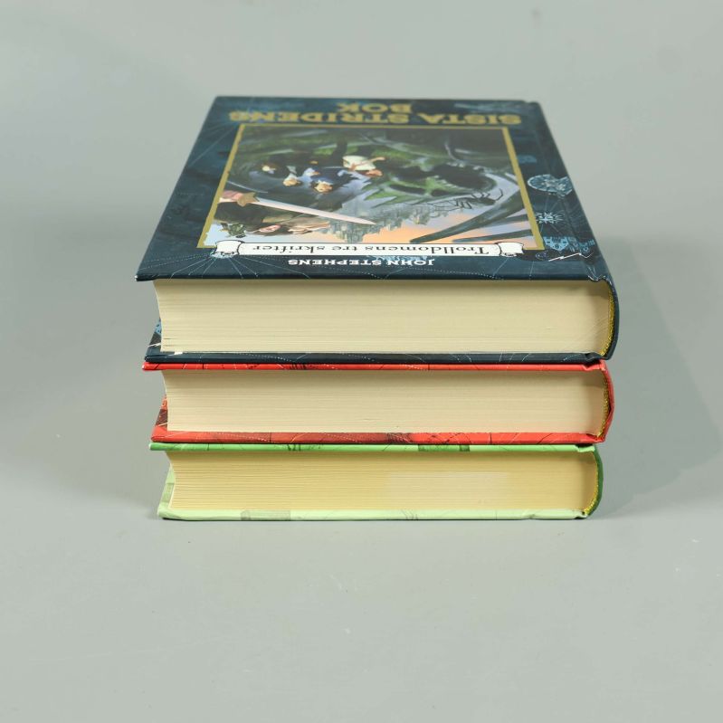 Tre böcker staplade med översta bokens framsida synlig