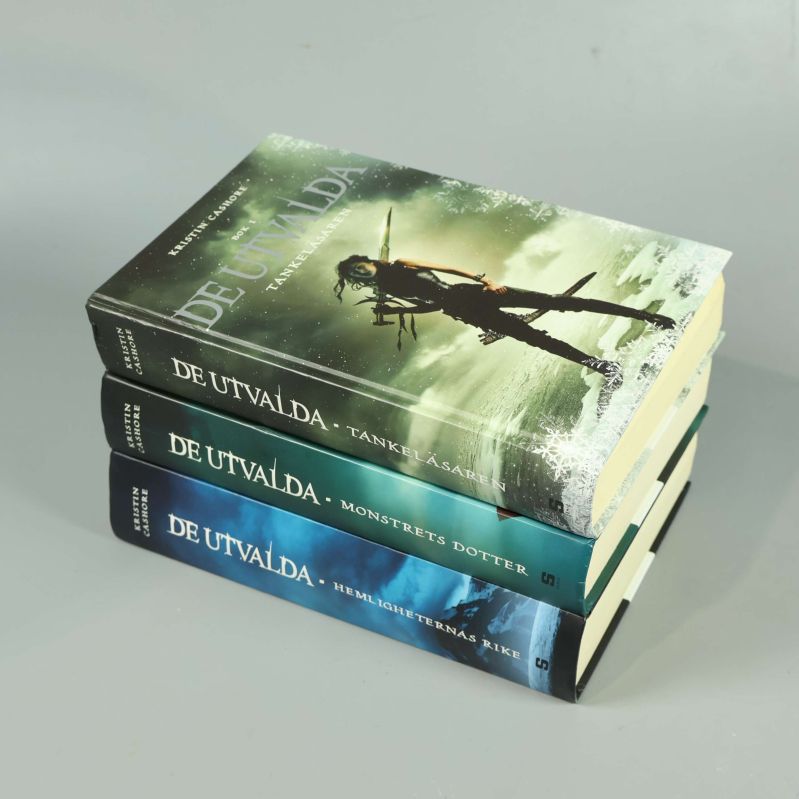 Tre böcker ur De utvalda serien staplade med tydliga ryggar