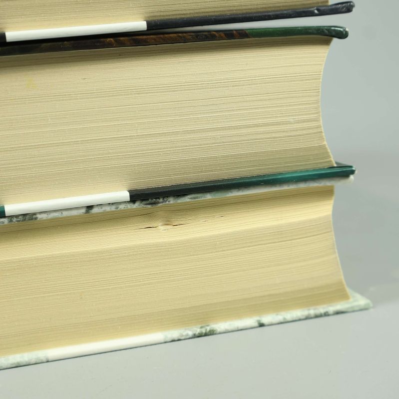 Närbild på bokkant från De utvalda, några småmärken syns