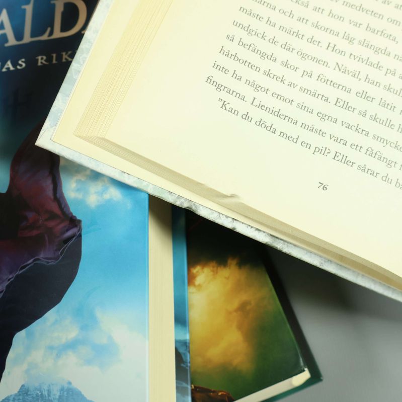 Uppslagen bok ur De utvalda, sidan 76 visas nära hörnet