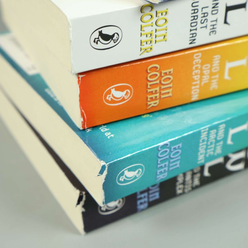 Närbild på mindre slitage vid ryggarna på Artemis Fowl-böcker