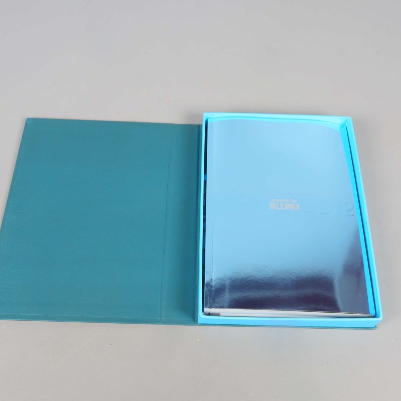 Uppslagen samlingsbox med ett häfte och övrigt innehåll i metallic blå design