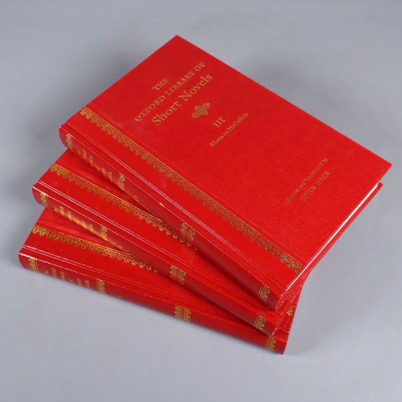 Tre röda böcker med guldfolierade titlar staplade snett