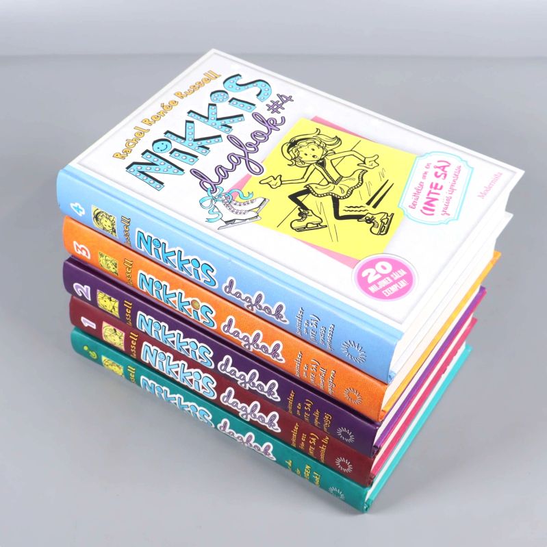 Fyra böcker ur Nikkis dagbok-serien staplade, synliga färgglada omslag och ryggar