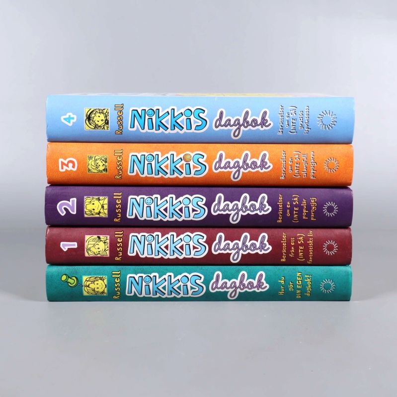 Nikkis dagbok-serien del 1 till 4 ligger sida vid sida, tydliga ryggar och titlar