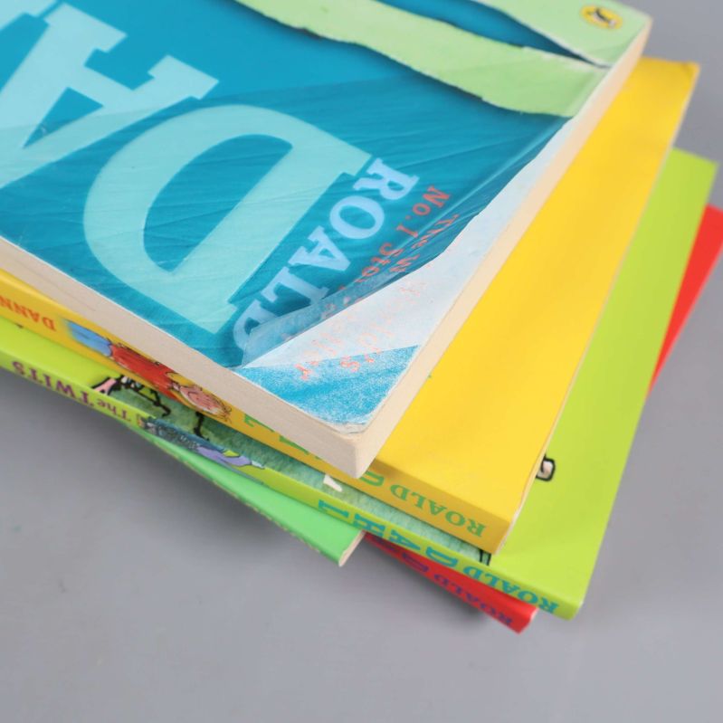 Böcker staplade på varandra med slitage på en av pärmarna synlig