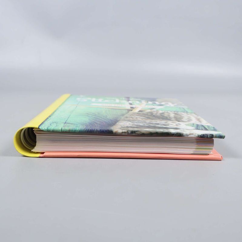 Stickningsboken uppskjuten från sidan med färgstarka pärmar