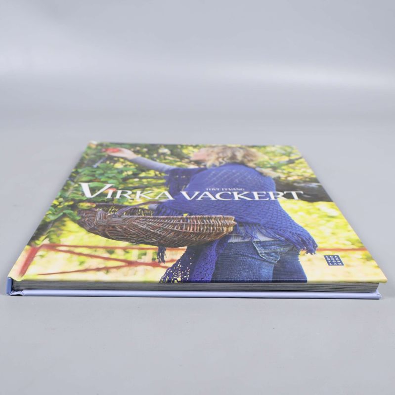 Boken Virka vackert liggande stängd mot grå bakgrund