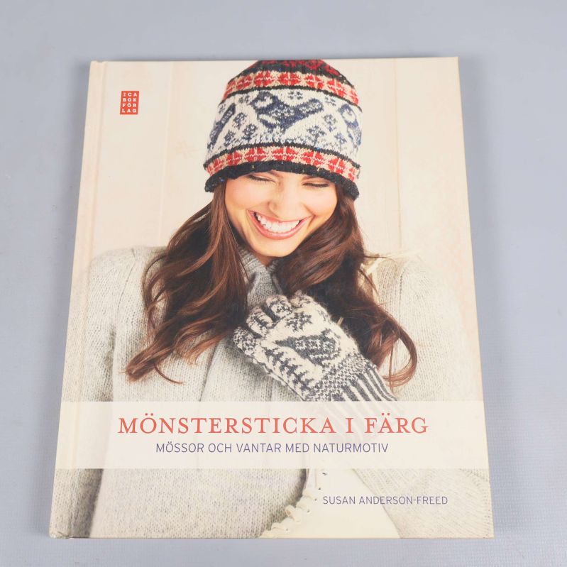 Framsida av stickbok med kvinna i stickad mössa och vantar