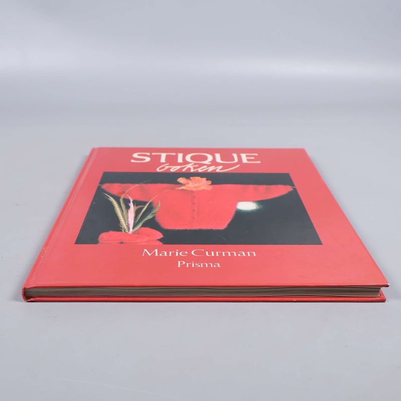 Boken Stiqueboken liggande med synlig pärm och sidor