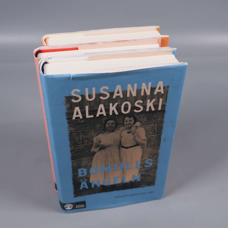 Tre böcker staplade, överst Bomullsängeln av Susanna Alakoski