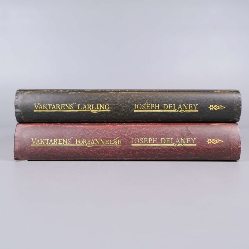 Ryggen av båda böckerna med titlar och författarnamn i guld