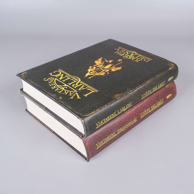 Två staplade böcker med gyllene tryck på pärmar och sidor