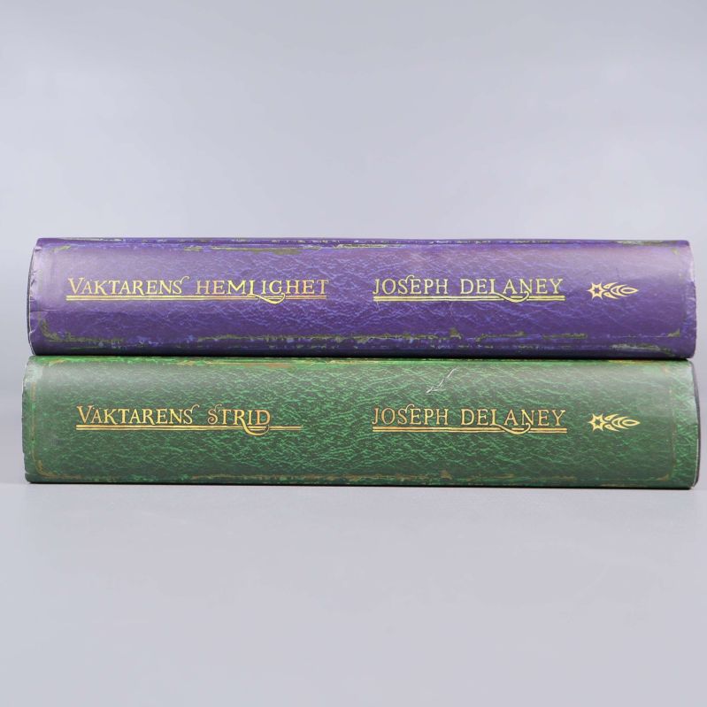 Ryggen på två inbundna Vaktaren-böcker med guldtext