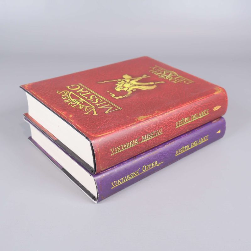 Två tjocka böcker staplade snett med tydliga omslagstitlar