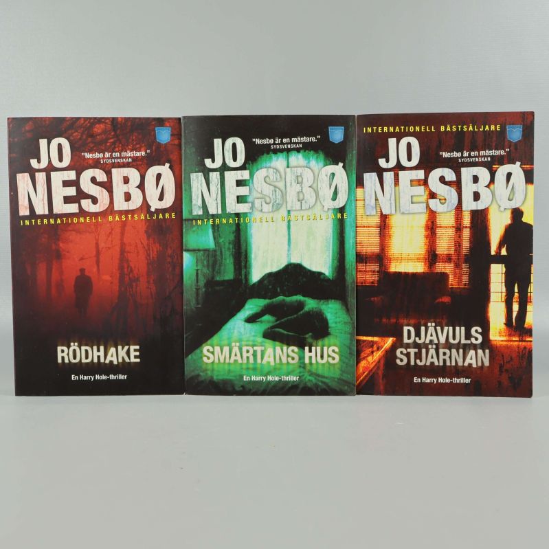 Tre pocketböcker av Jo Nesbø uppradade med framsidan utåt: Rödhake, Smärtans hus, Djävulsstjärnan