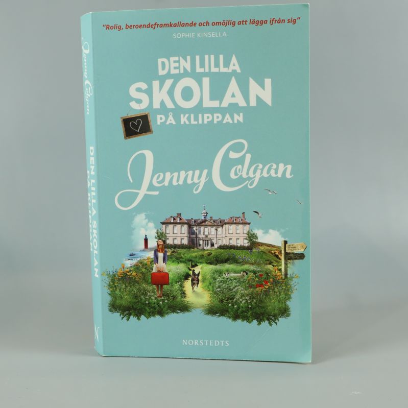 Framsida av boken Den lilla skolan på klippan, pastellblått omslag med illustration