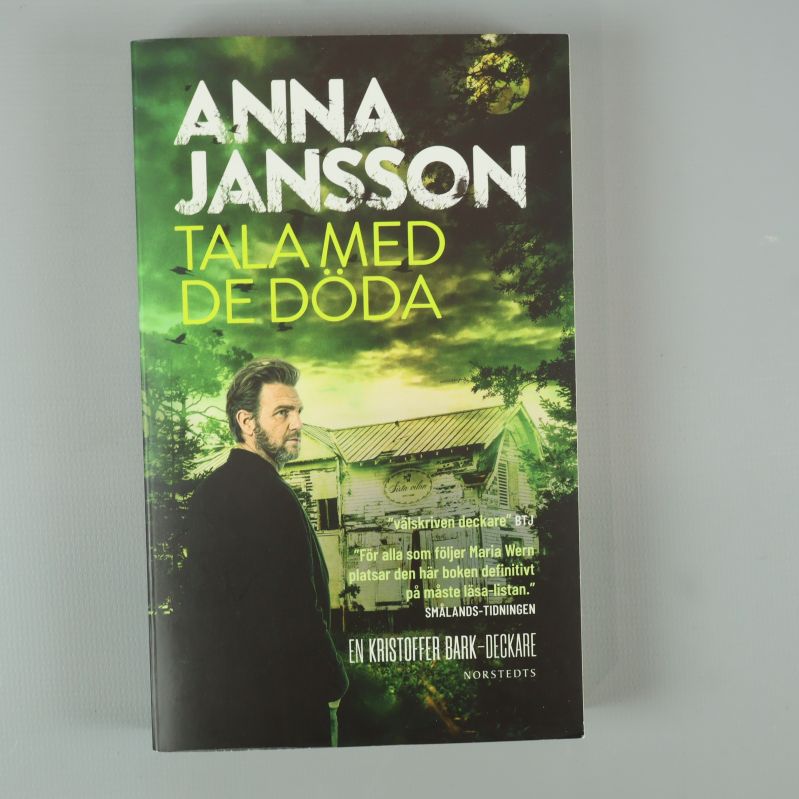 Framsida av Tala med de döda av Anna Jansson med grönt omslag och huvudpersonen på bild