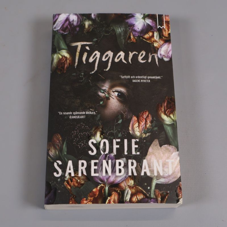 Framsida av boken Tiggaren av Sofie Sarenbrant med färgstarka blommor