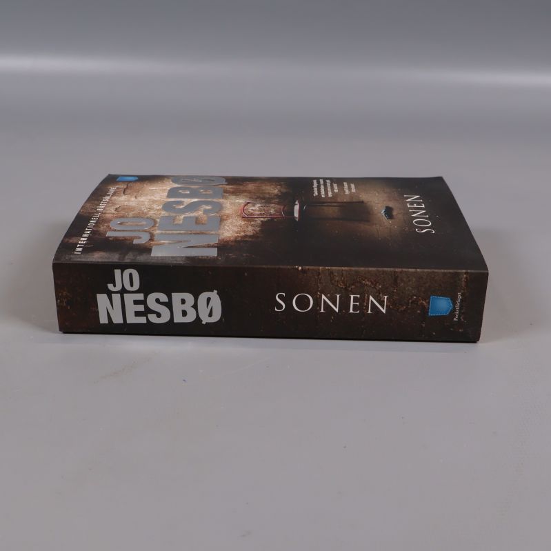 Sonen av Jo Nesbø sedd från sidan med bokrygg synlig