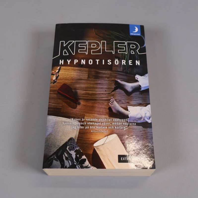 Framsidan av boken Hypnotisören med tydlig titel och grafiskt omslag