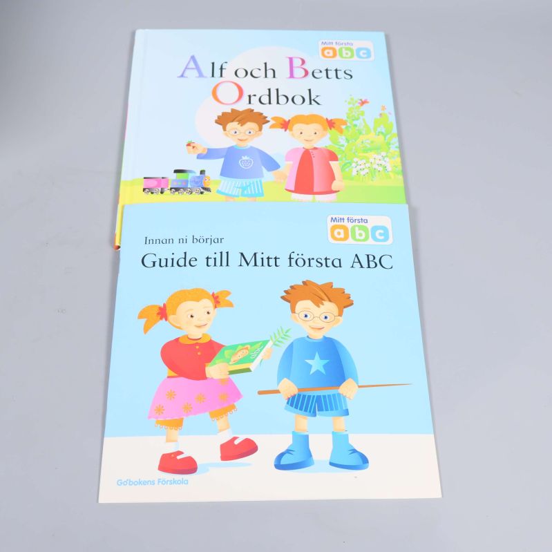 Alf och Betts Ordbok och Guide till Mitt första ABC uppslagna på golvet med framsidorna synliga