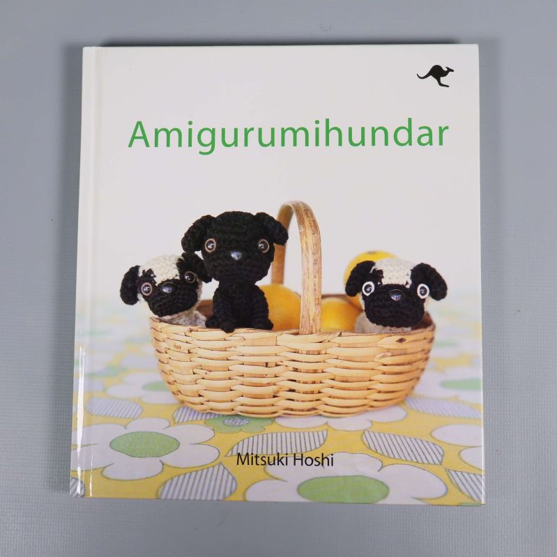 Framsida av boken Amigurumihundar med virkade hundar i korg
